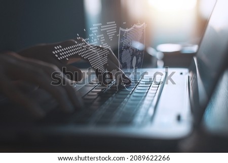 Hacker using laptop on the desk to hacking system with binary code and upload the malware with virtual screen display binary code, bar graph and world maps on the background.
