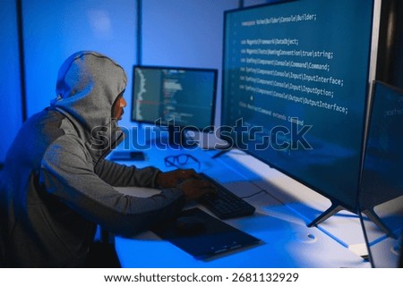 Hacker Using Multiple Computers For Stealing Data On Desk.