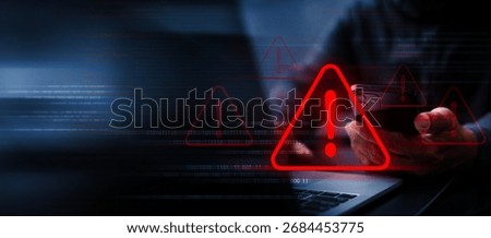 Hacker using a smartphone and laptop with a glowing red alert symbol. The image represents cybercrime, phishing attacks, data breaches, identity theft, and online security risks.