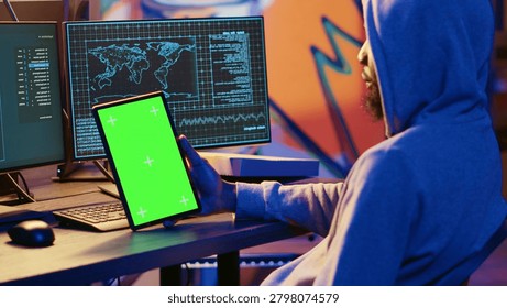 Hacker using VPN as anonymity tool to mask his online identity while committing data breaches using green screen tablet, Cybercriminal in bunker masking his location, hacking with mockup device.