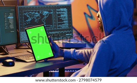 Hacker using VPN as anonymity tool to mask his online identity while committing data breaches using green screen tablet, Cybercriminal in bunker masking his location, hacking with mockup device.