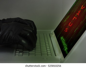 Hacker wearing black gloves using a laptop injecting a virus