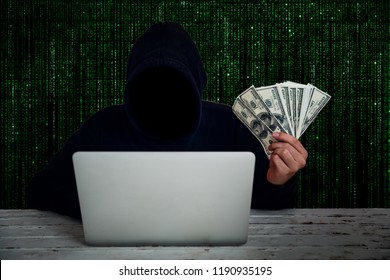 Hacker Wearing Black Hooded With Computer Hacking And Stealing Big Data And Finance Information Showing Money On Hand With Green Binary Code Background