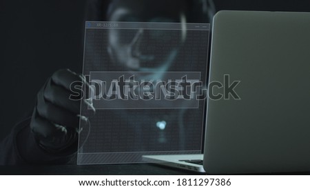 Hacker wearing black mask pulls DARKNET tab from a laptop
