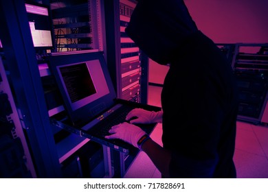 Hacker will hacking and steal data information in the server room of the data center and blur command on monitor of server and red "hacking" text on smart watch