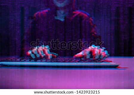 Hacker working with computer in dark room with digital interface around. Image with glitch effect.