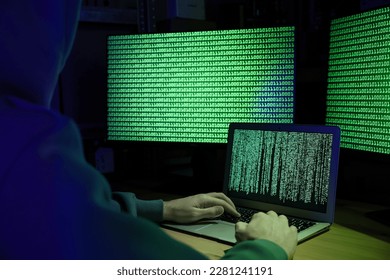 Hacker working with computers at wooden table indoors, closeup. Cyber attack