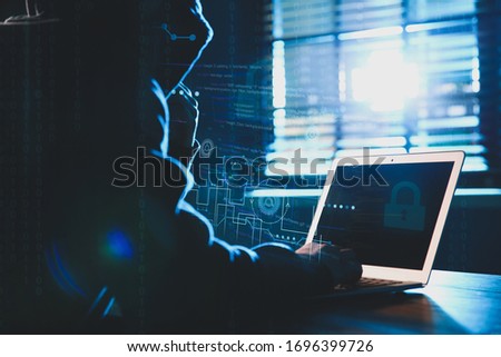 Hacker working with laptop at table indoors. Cyber attack [[stock_photo]] © 