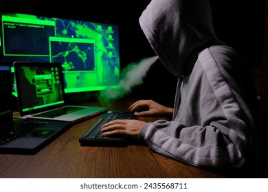 A hacker working on the tree monitor in dark place.