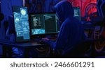 Hackers in dark room running code to breach defenses and exploit weaknesses in computer systems. Evil developers in basement getting past companies security networks, handheld camera shot