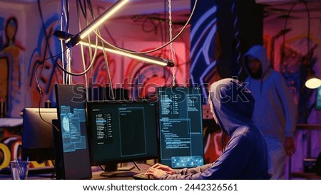 Hackers in underground hideout discussing technical knowhow details before using bugs and exploits to break into computer systems and access valuable data, finding best approach to bypass firewalls
