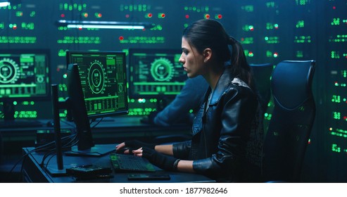 Hackers using computer for organizing massive data breach attack on corporate servers. Secret location surrounded by displays, servers and cables.