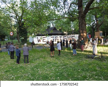Hackney, London / UK - May 28 2020: People in Hackney mourn local people who have died due to coronavirus in front of a sign which reads "We Grieve", most of the people who died are BAME heritage.