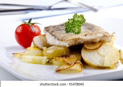 Haddock Fillet On A Plate With Grilled Potato And Garlic