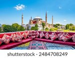 Hagia Sophia in Istanbul, Turkey. Great panoramic view of Istanbul from high terrace decorated traditional colorful ornamental pillows and carpets and still life.