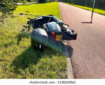 The Hague, Netherlands - August 09 2021 : An Abandoned And Broken Rental Share Scooter Along A Bike Path