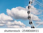 The Hague, Netherlands - July 10, 2024: Part of a ferris wheel in Scheveningen at the pier in the summer. Blue sky with clouds in the background. The Hague, Netherlands.