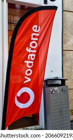 The Hague, The Netherlands - October 8 2021: Dutch Telecommunications Company Vodafone Name Banner Flag In Front Store, Merge With Ziggo Offering Cable TV, Internet And Telephony Services In Holland 