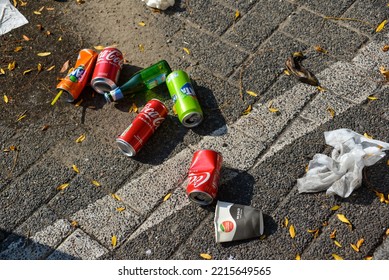 The Hague, The Netherlands - September 11 2022: Colorful Empty Drink Cans On Street, Tea Paper Cup, Beer Bottle And Softdrink Tin Cans Thrown As Litter On Street In Dutch City Centre, Fanta, Coca Cola