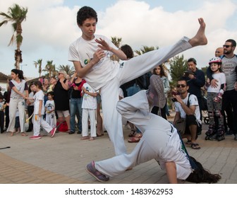 Haifa, Israel - April 28th 2019: Roda (Capoeira circle) at the beach promenade. 2 children of the group playing inside.