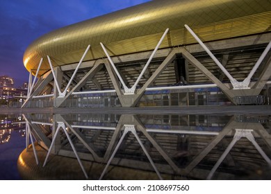 HAIFA, ISRAEL -JAN 7, 2021: Sammy Ofer Stadium Reflected In A Winter Puddle, Exterior Night View Of The New Sami Ofer Soccer Stadium, New Home Base Of Maccabi Haifa Fc Football Club. 