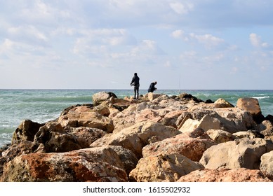 Haifa, Israel, January 10, 2020: fishermen working in the rocky shore of the mediterranean sea in Dado beach, north of Israel