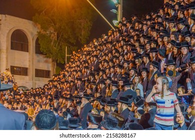 Haifa, Israel - May 18, 2022: Lag BaOmer holyday celebration of the ultra-orthodox Jewish Vizhnitz community, with a kid watching the men crowd. Haifa, Israel