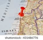 Haifa marked on map with red pushpin. Selective focus on the word Haifa and the pushpin. Pin is in an angle. Midground is sharp while foreground and background is blurry.