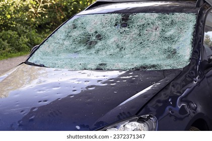 Hail damage to a car. Large hailstones have completely destroyed a car