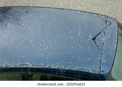 Hail falling over car roof. Hailstones can damage the bodywork. - Shutterstock ID 2252916621