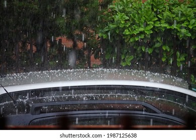 Hageleisbälle auf dem Autodach während eines schweren Sommersturms.