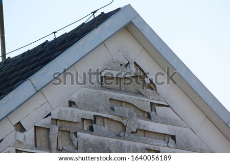 hail and storm damage at house wall, stormy weather, Holes in exterior siding in home from damage by hail storm , climate change, danger