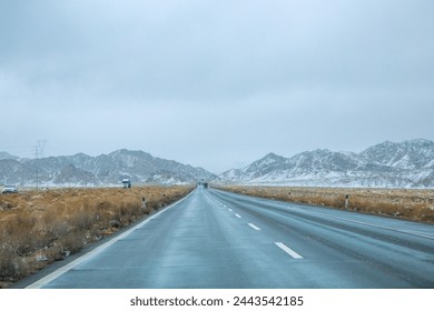 Hainan Mongolian and Tibetan Autonomous Prefecture, Qinghai Province-Grasslands and roads under the snow-capped mountains - Powered by Shutterstock