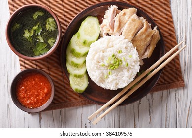 Hainanese Chicken Rice With Cucumber Closeup On A Plate And Broth. Horizontal Top View
