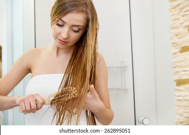 Hair. Beautiful Blond Brushing Her Wet Hair. Hair Care. Spa Beauty Model