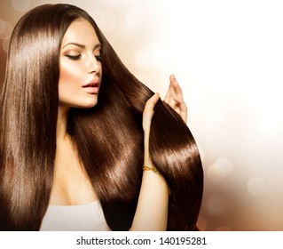 Hair. Beauty Fashion Model Woman touching her Long and Healthy Brown Hair. Beauty Brunette Girl isolated on white background.