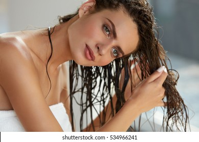 Hair And Body Care. Portrait Of Beautiful Young Female Model After Bath Applying Hair Oil. Closeup Of Sexy Woman In Towel Drying Wet Long Hair. Health And Beauty Concept. High Resolution Image 