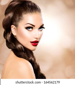 Hair Braid. Beautiful Woman With Healthy Long Brown Hair. Hairdressing. Hairstyle. Beauty Glamour Fashion Model Girl Portrait. Perfect Skin And Makeup Holiday Make Up. Blue Eyes And Red Lipstick