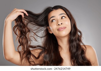 Hair care, beauty and woman in studio with salon, shiny and healthy treatment for confidence. Wellness, soft and female person with grooming routine for long and wavy hairstyle by gray background. - Powered by Shutterstock