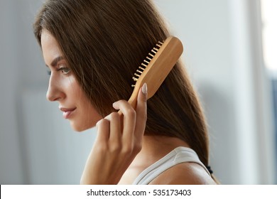 Hair Care. Closeup Of Beautiful Woman Hairbrushing Hair With Brush. Portrait Of Sexy Female Woman Brushing Long Straight Healthy Hair With Hairbrush. Health And Beauty Concept. High Resolution Image