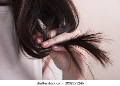 Hair care concept. Young woman with long split ended hair on pastel beige background. Close up - Shutterstock ID 2039273246
