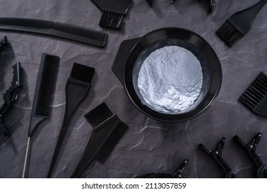 Hair Color Dye Powder In A Black Plastic Mixing Bowl On A Black Background.