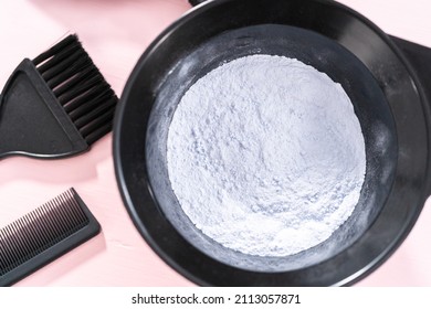 Hair Color Dye Powder In A Black Plastic Mixing Bowl On A Pink Background.