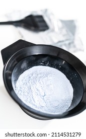 Hair Color Dye Powder In A Black Plastic Mixing Bowl On A White Background.