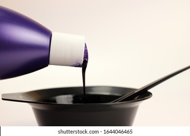 Hair dye is poured from a bottle into a bowl isolated on white - Shutterstock ID 1644046465