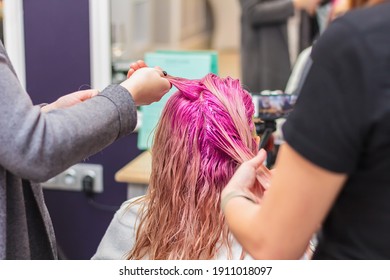 Hair dyeing for a girl in a beauty salon, long hair pink. Hair care - Powered by Shutterstock