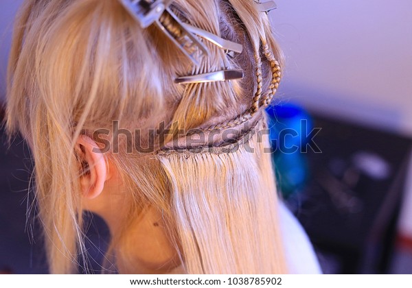 hair extension for Hollywood technology for a\
girl, hairdresser, sewing hair to a pigtail, corn rows, strands of\
hair close-up on a girl with blond hair, divided into partings,\
hairpins, segments