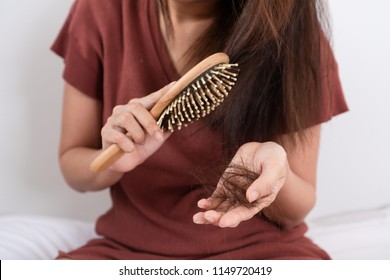 Hair Fall Problem. Young Asian Woman With Comb And Problem Hair On White Background. Beautiful Girl Looking Hair Loss From Comb. Hair Care And Beauty Concepts.