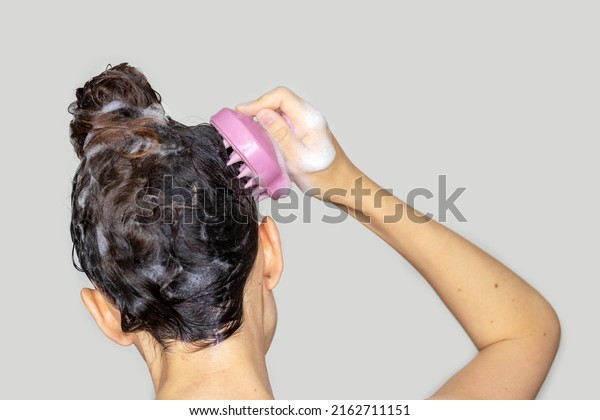 hair growth\
stimulating, scalp massage.woman using  pink scalp massager shampoo\
brush with silicone,flexible bristels.hair care,head\
relaxation.shampoo foam on\
hair,hand,isolated
