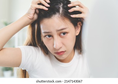 Hair loss problem, Asian woman look at scalp worry about balding.